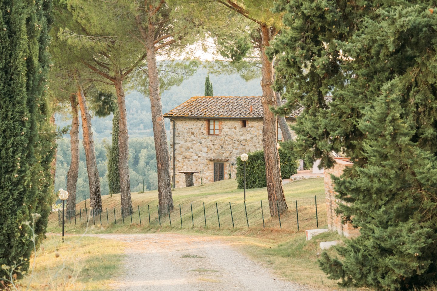 Una casa colonica in pietra si trova alla fine di un sentiero sterrato.