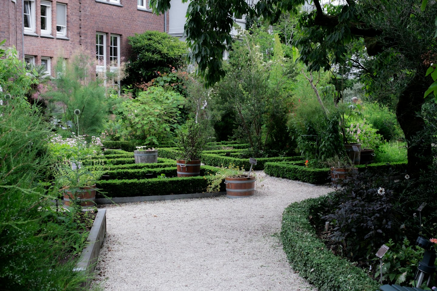 Sentieri ghiaiosi si snodano in un giardino con siepi e aiuole.